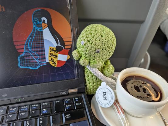 Logo des linustag villach am laptop, baby cuthulu und ein verlängerter