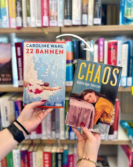 Zwei Hände halten vor einem Bücherregal zwei Romane in die Kamera. Links ist „22 Bahnen“ von Caroline Wahl mit einem hellblauen Cover zu sehen, rechts „Chaos“ von Andréa Ager-Hanssen mit einem dunkelblauen Cover und einer gemalten Frauenfigur. Ein weißer, geschwungener Pfeil zeigt vom Buch „22 Bahnen“ auf „Chaos“. Im Hintergrund stehen unscharf weitere Bücher in den Regalen.