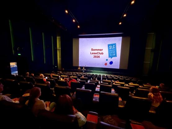 Kinosaal, auf der Leinwand steht "SommerLeseClub 2026"